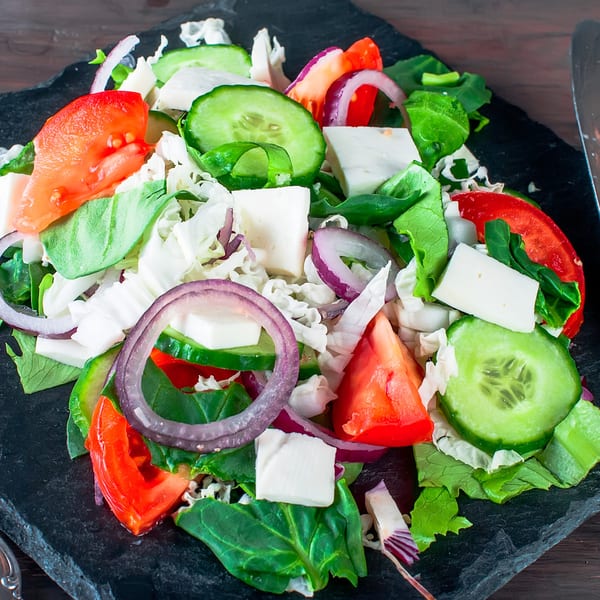 Goodi's Greek salad with tomatoes, cucumbers, red onions, feta cheese, and mixed greens.